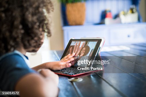 Fille de vidéoconférence avec la mère sur tablette numérique Fille de vidéoconférence avec la mère sur tablette numérique