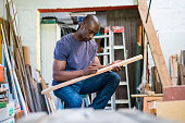 Male carpenter marking on plank in workshop