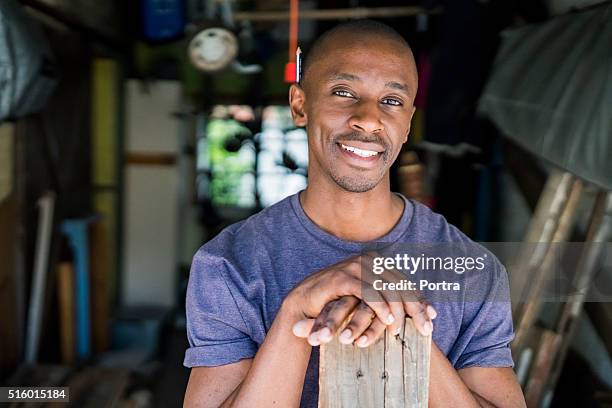confident carpenter with plank in workshop - carpenter portrait stock pictures, royalty-free photos & images