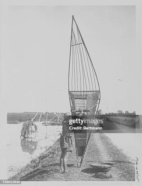 Indochina: Photo shows a native fisherman on the delta of the river at Tonkin at French Lido China, with his queer native outfit for fishing. It is...