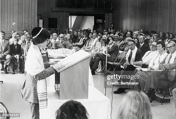 Thirteen year old Scott Gordon reads before an audience of friends and family, his parents watch from the far right, during his Bar Mitzvah...