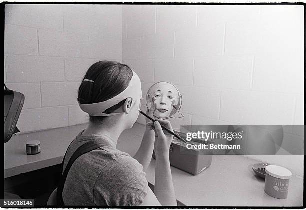 Barbara Nadel of New Haven, Conn., uses mirror as she compltes facial makeup before entertaining the crowd attending a circus performanc here...