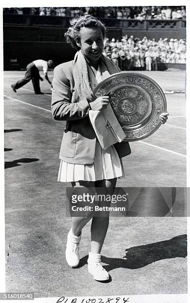 Wimbledon, England: "Little Mo" takes Wimbledon. 17 year old Maureen Connolly of San Diego, CA walks off with the Wimbledon court with her trophy,...