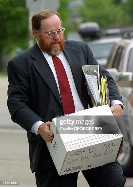 Utah polygamist Tom Green carries a box of files as he enters the 4th District Court in Provo, Utah, for start of the third day of his trial on...