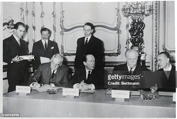 London, England: United States Secretary of State John Foster Dulles signs the nine power pact that concluded the conference on the rearming of...