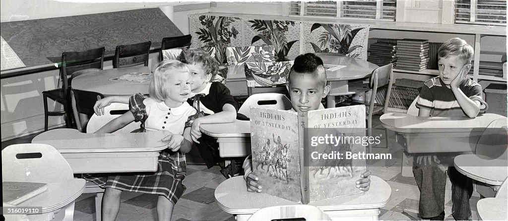 Indian Boy Reading In White Classroom