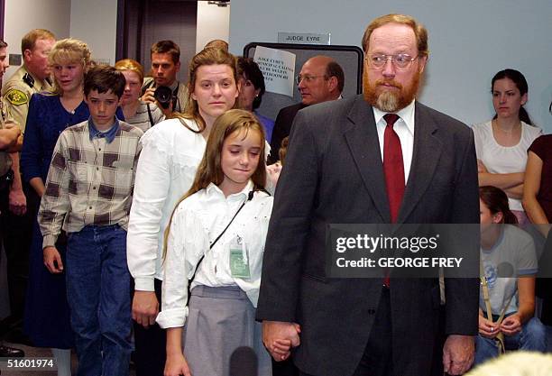 Utah polygamist Tom Green walks out of the court room holding his daughter Sierra's hand, as the rest of the family follows, after he was convicted...