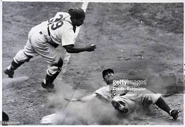 New York, NY: Flat on his back in a cloud of dust, Murtaugh, of the Pittsburgh Pirates, is shown out at home plate, with catcher Campanella, of the...