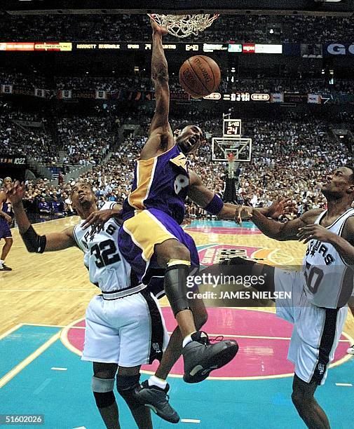 Kobe Bryant of the Los Angeles Lakers dunks the ball between Sean Elliott and David Robinson of the San Antonio Spurs during game 1 of the NBA...