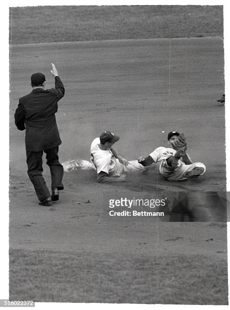 New York, NY: Making good with a low throw from Yankee catcher Yogi Berra, Yank shortstop Phil Rizzuto rolls away after tagging Dodger Billy Cox, who...
