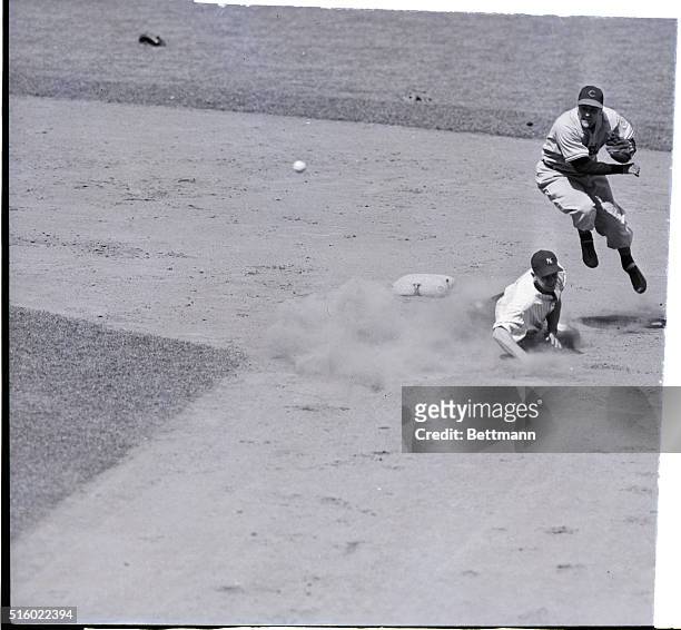 New York, NY: Cleveland shortstop Lou Boudreau takes to the air to send the ball whizzing to first baseman Les Fleming for a double play in the...