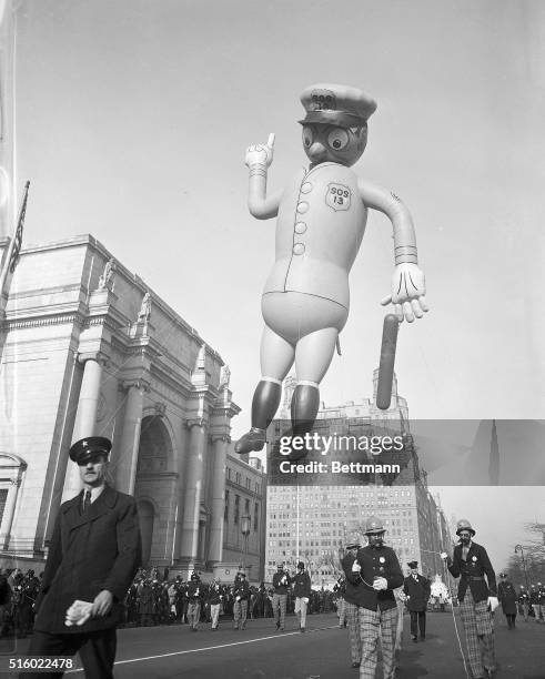 Parade balloon in the shape of a New York City cop is led down the street during the annual Macy's Thanksgiving Day Parade.