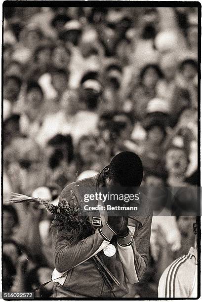 Los Angeles, CA- United States' Carl Lewis, winner of the 100m at the 1984 Olympics at Los Angeles, prays during the medal ceremony. He won the race...