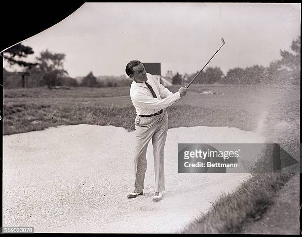 Greenwich, CT- Billy Burke, the National Open golf champion, illustrates how he plays a high ball from a sand trap. It was a couple such shots that...