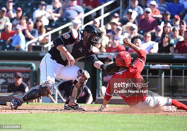 David Fletcher of the Los Angeles Angels of Anaheim is tagged out sliding into home plate by Adam Moore of the Cleveland Indians during the ninth...