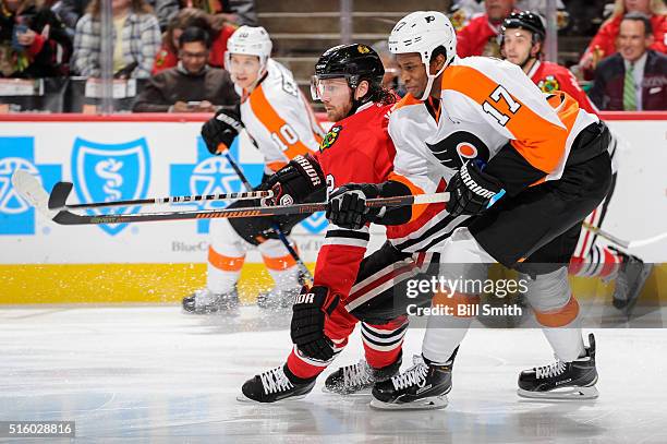 Duncan Keith of the Chicago Blackhawks and Wayne Simmonds of the Philadelphia Flyers skate in the first period of the NHL game at the United Center...