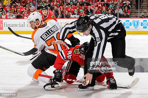 Linesman Ryan Galloway falls over Teuvo Teravainen of the Chicago Blackhawks and Pierre-Edouard Bellemare of the Philadelphia Flyers in the first...