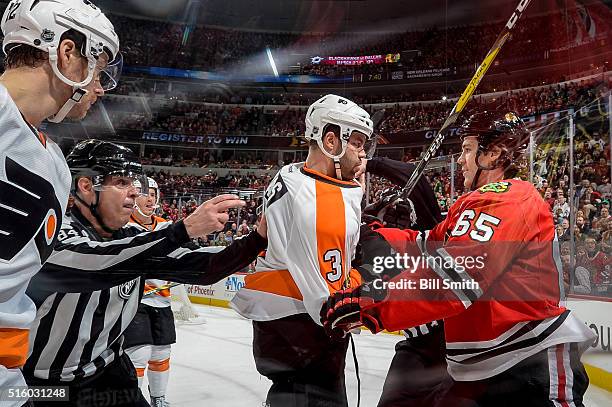 Linesman Tony Sericolo breaks up a scuffle between Radko Gudas of the Philadelphia Flyers and Andrew Shaw of the Chicago Blackhawks in the first...