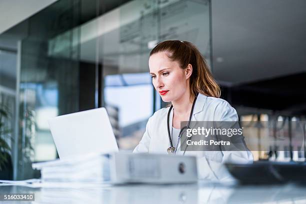 female doctor using laptop in clinic - doctor laptop stock pictures, royalty-free photos & images