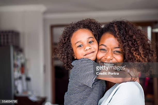 feliz madre e hija abrazar en el hogar - madre soltera fotografías e imágenes de stock