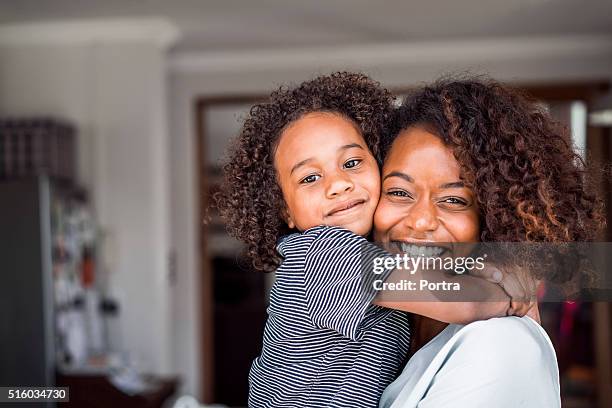 heureuse mère et fille embrassant à la maison - black mom photos et images de collection
