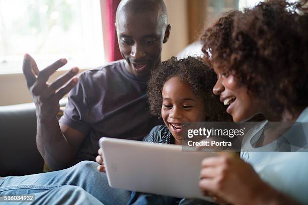 happy family using tablet computer on sofa - surprised woman looking at tablet stock pictures, royalty-free photos & images