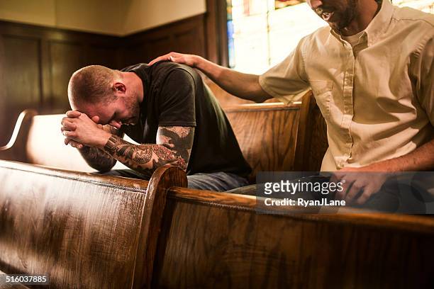 männer beten in der kirche - kirche stock-fotos und bilder