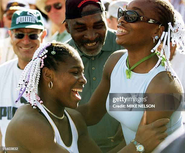 Serena Williams of the US celebrates her Evert Cup final victory over Steffi Graf of Germany with her sister Venus and her father Richard 13 March...