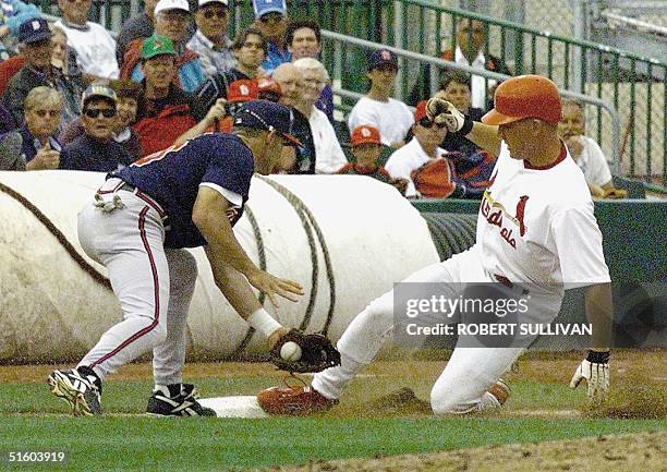 Drew of the St. Louis Cardinals slides into third base as Marty Malloy of the Atlanta Braves applies a late tag 15 March 1999 in their spring...