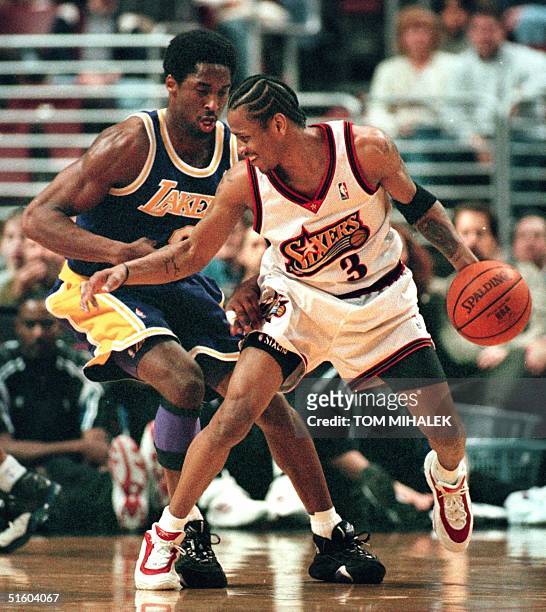 The Philadelphia 76ers point guard Allen Iverson smiles as he moves past the Los Angeles Lakers Kobe Bryant on his way to the basket 19 March 1999 in...