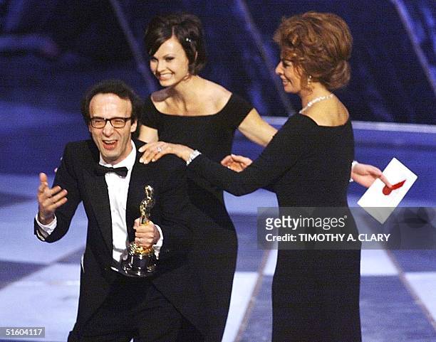 Italian director Roberto Benigni is led off the stage by presenter-actress Sophia Loren after winning the Oscar for Foreign Language Film for his...