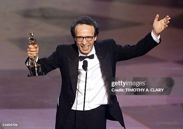 Italian actor Robero Benigni holds his Oscar after winning the Best Performance by an Actor in a Leading Role for his part in the movie "Life is...