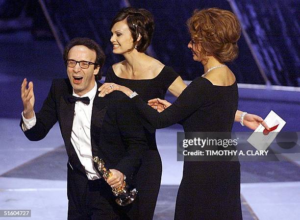 Italian actor and director Roberto Benigni is congratulated by Italian actress Sophia Loren after receiving the Oscar for Best Foreign Language Film...