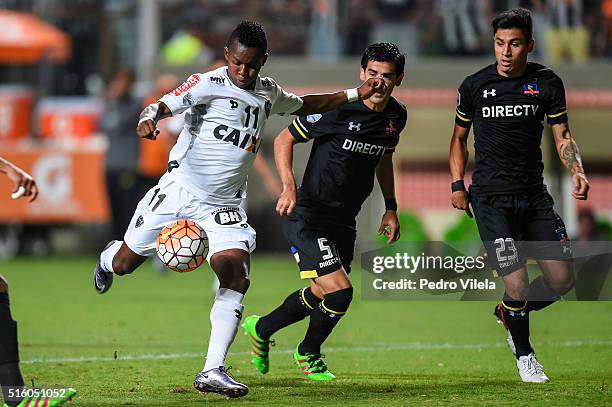 Cazares of Atletico MG and Julio Barroso and Claudio Baeza of Colo Colo battle for the ball during a match between Atletico MG and Colo Colo as part...