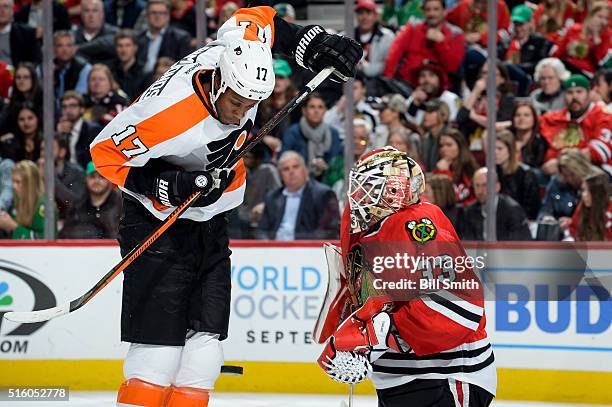 The puck flys toward goalie Scott Darling of the Chicago Blackhawks, past Wayne Simmonds of the Philadelphia Flyers, in the second period of the NHL...