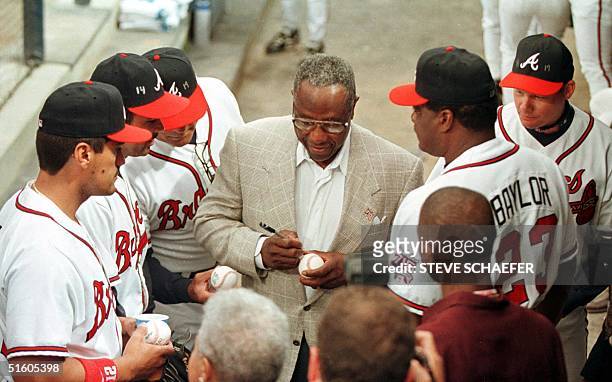 Hank Aaron signs autographs for some of the Atlanta Braves players before ceremonies that unveiled the Hank Aaron Award on the 25th anniversary of...