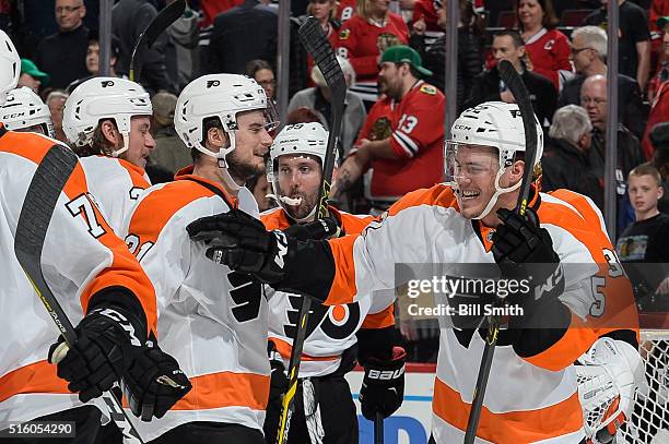 Nick Cousins of the Philadelphia Flyers celebrates with Scott Laughton after defeating the Chicago Blackhawks 3 to 2 during the NHL game at the...