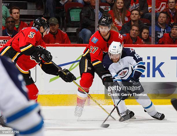 Dougie Hamilton of the Calgary Flames battles against Matt Halischuk of the Winnipeg Jets at Scotiabank Saddledome on March 16, 2016 in Calgary,...