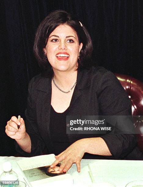 Former White House intern Monica Lewinsky looks up as she signs her book, 'Monica's story', during a signing 23 April, 1999 at a book store in Fort...
