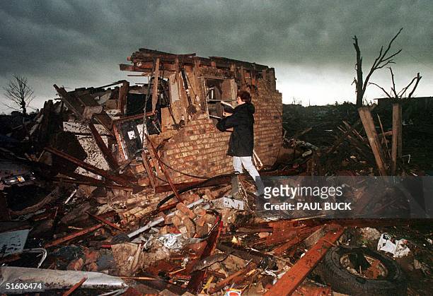 Peggy Lipscomb salvages belongings from what is left of her home 04 May, 1999 in southeast Oklahoma City following a series of deadly tornados that...