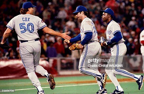 Toronto Blue Jays relief pitcher Danny Cox congratulates Blue Jays first baseman Paul Molitor 19 October 1993, in Philadelphia, PA, after Molitor...