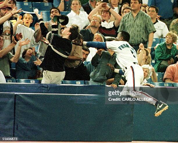 Toronto Blue Jay Tony Fernandez jumps into the stands to catch a foul ball hit by an Oakland A in the early innings of their game at Toronto's...