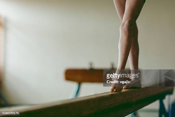 femmina ginnasta piedi su trave, sezione inferiore - trave foto e immagini stock