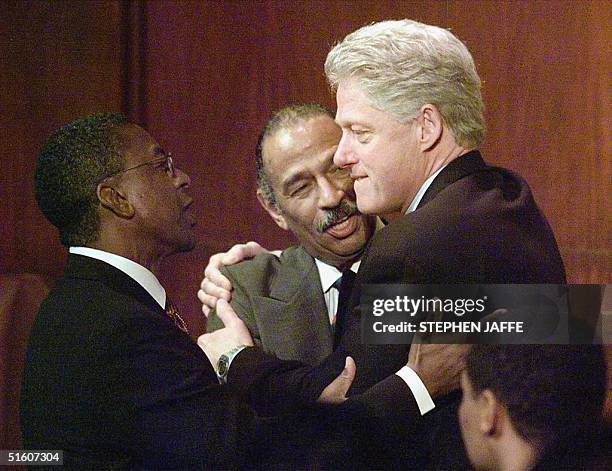 President Bill Clinton hugs Congressman John Conyers , who is up for reelection, along with Black Entertainment CEO Robert Johnson at the "Conyers...