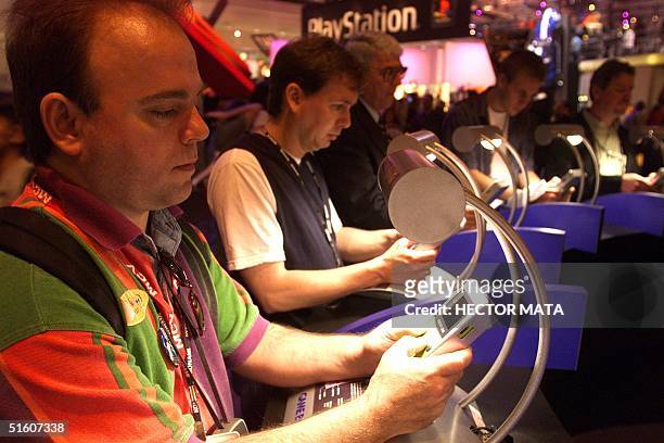 Group of men play video games with small screens at the Electronic Entertainment Expo at the Los Angeles Convention Center 14 May 1999. More than...