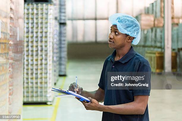 ethnic factory worker making notes in aluminium plant - lagos nigeriaanse staat stockfoto's en -beelden