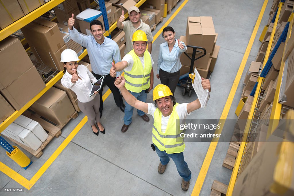 Workers at a warehouse with thumbs up
