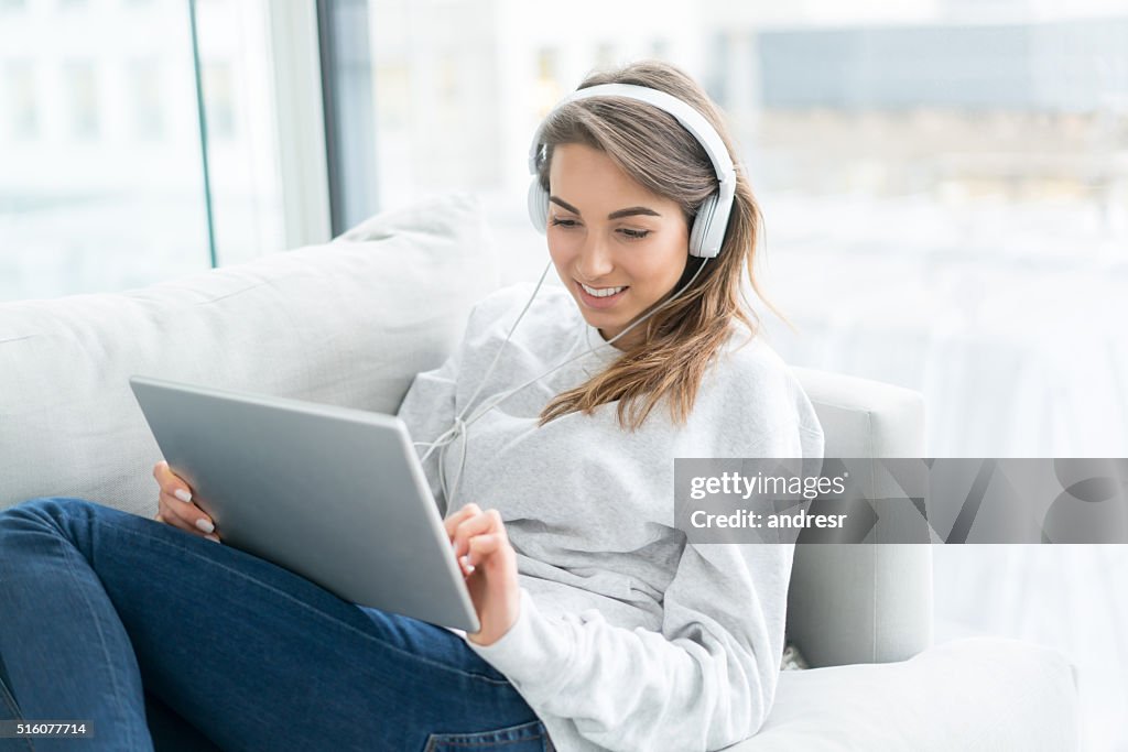 Woman relaxing at home using a digital tablet