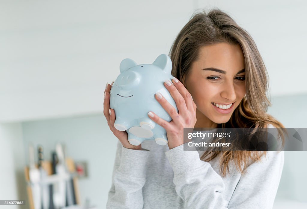 Mujer feliz ahorrando dinero en una alcancía