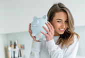 Happy woman saving money in a piggybank